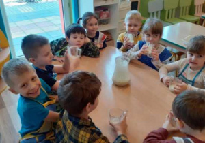 Dzieci piją pyszny jogurt owocowy.